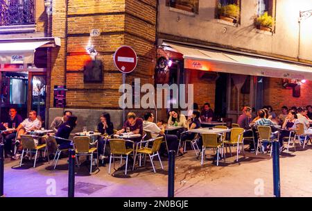 Tolosa, Francia - folla giovani che condividono pasti all'aperto,, nel centro storico, Street Restaurant, Terrazza, edifici di appartamenti, a luci notturne, Foto Stock