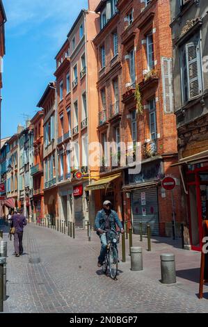 Tolosa, Francia - persone in bicicletta nel centro storico, Street Center, edifici di appartamenti Foto Stock