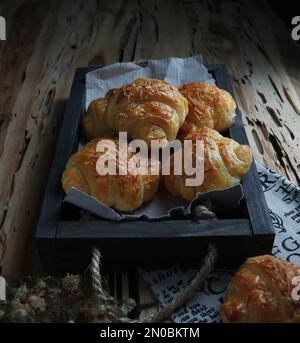 Mini croissant fatti in casa su un vassoio di legno nero Foto Stock