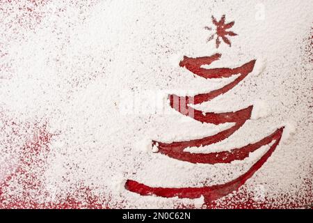 Albero di Natale disegno dito, su zucchero in polvere, sfondo di vacanza minimo Foto Stock