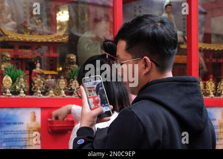 Ho Chi Minh City, Vietnam. 5th febbraio 2023. Un uomo che filma la macchina per raccontare la fortuna alla Pagoda di Van Phat. DAT Do/Alamy Live News Foto Stock