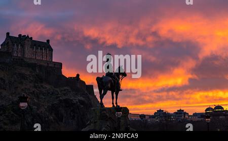 Edimburgo, Scozia, Regno Unito, 5th febbraio 2023. Regno Unito Meteo drammatico cielo colorato tramonto. Il tramonto ha trasformato i vivaci colori arancioni del cielo, visti sui Princes Street Gardens con il Royal Scots Greys Monument in una silhouette. Credit: Sally Anderson/Alamy Live News Foto Stock