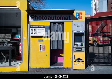 12.03.2022, Berlino, Germania, Europa - Stand fotografico per le fotografie dei passaporti accanto a un bancomat EC su un marciapiede nel quartiere di Mitte. Foto Stock