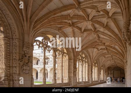 All'interno del chiostro del convento dei Jeronimos, con i suoi archi gotici decorati e il tetto a coste, turisti in background la visita, orizzonte Foto Stock