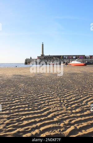 Faro sul Molo Margate a bassa tidea al sole invernale, nel Kent settentrionale, Regno Unito Foto Stock