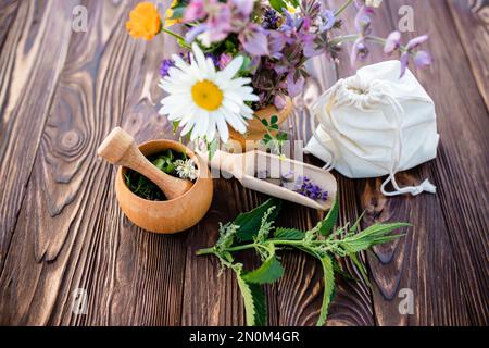 Ortica comune, o stinger , St. Erba di Giovanni, camomilla, trifoglio, arancio Calendula officinalis erbe medicinali vicino al mortaio. Sacchetto con erbe essiccate. Soft f Foto Stock