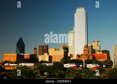 Il treno Trinity Express arriva a Dallas di fronte al centro affari e allo skyline del centro Foto Stock