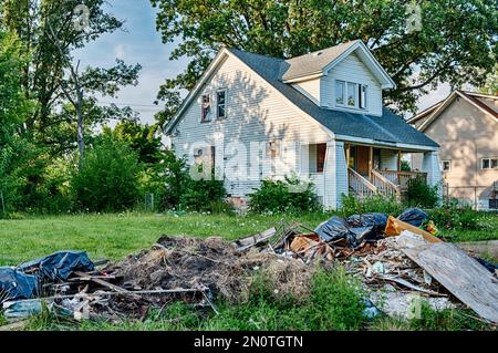 I detriti delle case danneggiate cucciolate la strada di fronte agli edifici abbandonati in Highland Park. Foto Stock