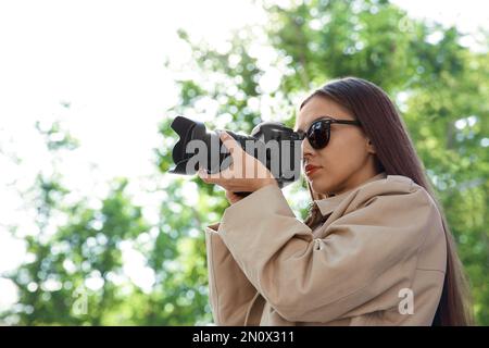 Detective privato con macchina fotografica spionaggio nel parco Foto Stock