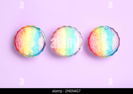 Rasatore di ghiaccio arcobaleno in ciotole di vetro da dessert su fondo lilla, piatto Foto Stock