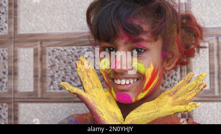 Mani o palme di giovani coperti di viola, giallo, rosso, blu Holi festival colori isolati Foto Stock