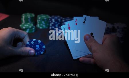 Il giocatore guarda l'arte mentre gioca a poker. Una combinazione di quattro assi, quattro di un genere, carte vincenti cadde Foto Stock