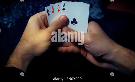 Il giocatore guarda l'arte mentre gioca a poker. Una combinazione di quattro assi, quattro di un genere, carte vincenti cadde Foto Stock