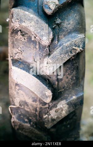 Battistrada in gomma volumetrico su un primo piano delle ruote del trattore. Modello di pneumatico fango per una maggiore capacità di cross-country sulle macchine agricole, foto verticale Foto Stock