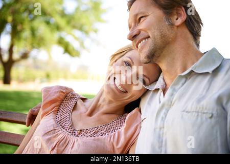 Approfittando di questa bella giornata. una coppia matura felice seduta su una panchina nel parco. Foto Stock