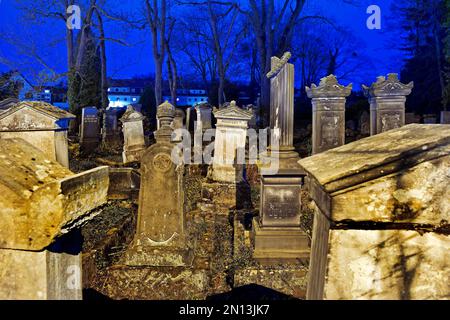 Cimitero ebraico di notte, sullo sfondo i nuovi edifici della strada an der Gerichtslinde, Göttingen, bassa Sassonia, Germania, Europa Foto Stock