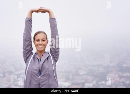 Respirare l'aria del mattino. una giovane donna che si prepara per una corsa stretching. Foto Stock