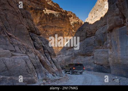 Auto spremitura attraverso il si restringe di Tito Canyon in Grapevine montagne, Parco Nazionale della Valle della Morte, CALIFORNIA, STATI UNITI D'AMERICA Foto Stock