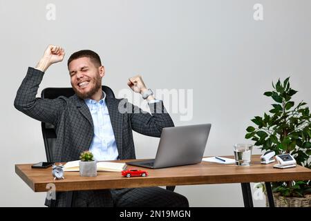 uomo seduto sulla sedia al tavolo e a riposo, utilizzando un computer portatile Foto Stock