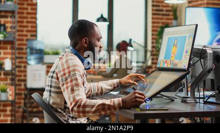 Un giovane retoucher professionista che modifica le immagini su un software di ritocco, lavorando con un tablet e una penna stylus. Artista editore che fa il lavoro di ritocco con la classificazione di colore, avendo abilità di fotografia. Foto Stock