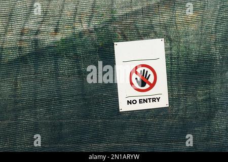 Nessun segno di ingresso con il gesto di arresto mano sulla recinzione Foto Stock