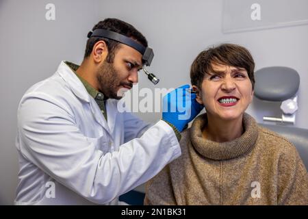 Donna anziana che ha controllo uditivo a un medico ent Foto Stock