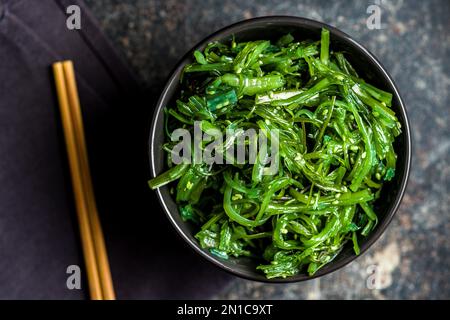Alghe verdi. Insalata di wakame giapponese nella ciotola. Vista dall'alto. Foto Stock