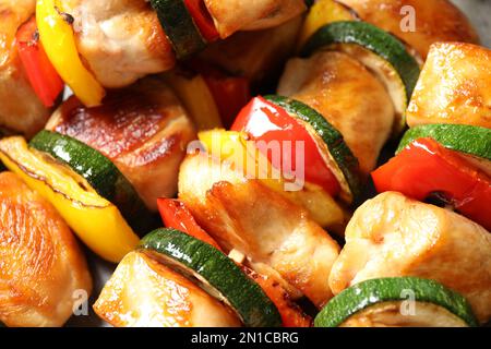 Deliziosi kebab di pollo shish con verdure come sfondo, primo piano Foto Stock