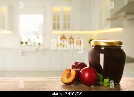 Vasetto con prugne sottaceto su tavolo in cucina. Spazio per il testo Foto Stock