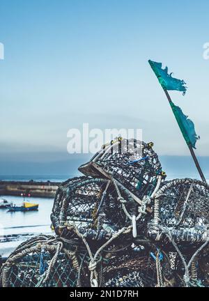 Le pentole di aragosta dei pescatori si asciugano sulla parete del porto, nell'intramontabile porto di pescatori di Staithes, sulla costa del North Yorkshire. Foto Stock