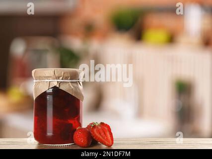 Vasetto con fragole sottaceto su tavolo in legno in cucina. Spazio per il testo Foto Stock