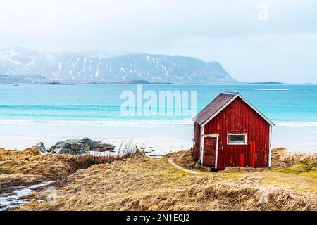 Cabina Rorbu tradizionale sulla spiaggia di Ramberg con vista sul mare cristallino, le isole Lofoten, Norvegia, Scandinavia, Europa Foto Stock