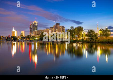 Skyline della città al crepuscolo, Danubio, Alte Donau, Vienna, Austria, Europa Foto Stock