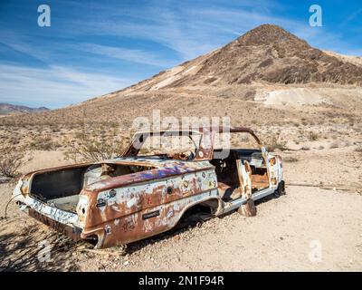 Auto abbandonata a Rhyolite, una città fantasma nella contea di Nye, vicino al Death Valley National Park, Nevada, Stati Uniti d'America, Nord America Foto Stock