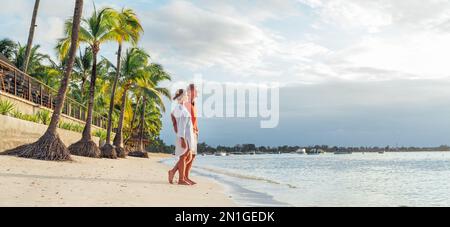 Coppia innamorata che abbraccia la spiaggia sabbiosa esotica mentre si cammina di sera sul mare di Trou-aux-Biches sull'isola di Mauritius godendo il tramonto. Persone relatio Foto Stock