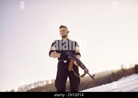 Soldato con armi nella foresta da qualche parte sopra il Circolo polare Artico Foto Stock