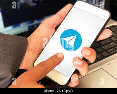 Applicazione mobile telegramma utilizzata dall'uomo, background editoriale Foto Stock