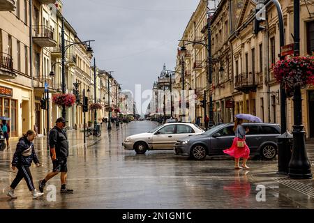 Lodz, Polonia - 16.07.2022: Piotrkowska - strada principale della città in un giorno piovoso Foto Stock