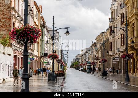 Lodz, Polonia - 16.07.2022: Piotrkowska - strada principale della città in un giorno piovoso Foto Stock