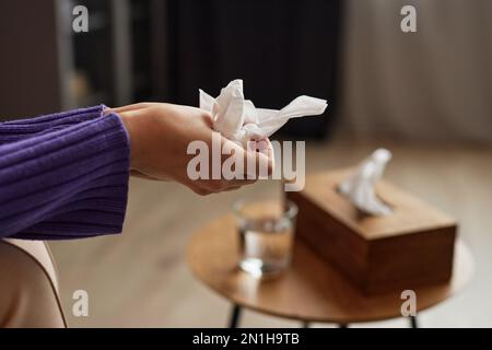 Mani di una giovane donna che tiene il fazzoletto di carta per pulire le lacrime quando si parla di problemi Foto Stock