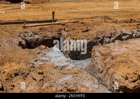 Costruzione cemento fondazione striscia per la costruzione di nuova casa preparazione trincee per il travaso di calcestruzzo in trincee Foto Stock