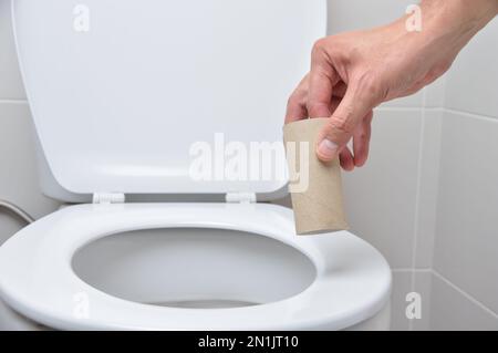 primo piano di una mano di un uomo con carta igienica Foto Stock