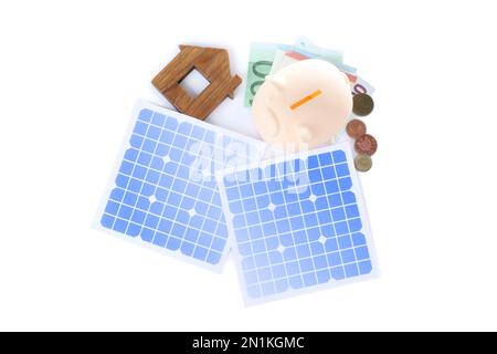 Composizione con pannelli solari e piggy bank su sfondo bianco, vista dall'alto Foto Stock