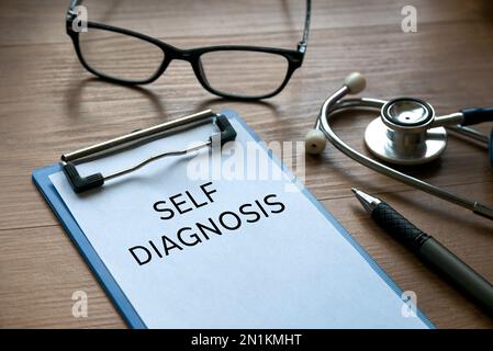 Messa a fuoco selettiva di occhiali, stetoscopio, penna e clipboard con carta scritta con autodiagnosi . Foto Stock