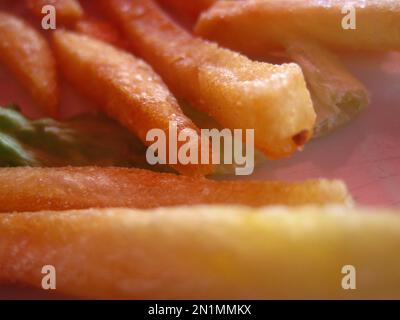 Primo piano di una manciata di patatine ben rosolate a forma di bastoncini Foto Stock