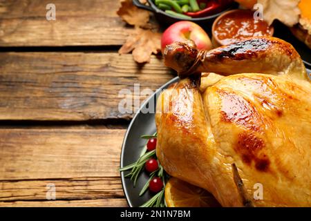 Festa tradizionale del giorno del Ringraziamento con deliziosi tacchino cotto e altri piatti di stagione serviti su tavolo in legno, primo piano. Spazio per il testo Foto Stock