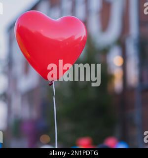 Palloncino rosso a LED in forma di cuore e ulteriore silhouette di cuore di notte. Romantico stile amore concetto, vacanza di San Valentino Foto Stock