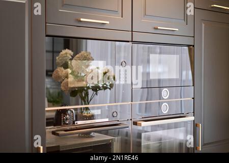 Forno elettrico con ventilazione dell'aria. Vista laterale dell'apparecchio di tecnologia moderna contro i mobili da cucina. Foto Stock