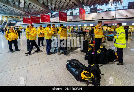 06 febbraio 2023, Hesse, Francoforte sul meno: Soccorritori dallo stand dell'organizzazione di aiuti '@Fire' nella sala partenze dell'aeroporto di Francoforte. Dopo un devastante terremoto in Turchia e Siria, ci si aspetta un gran numero di vittime. I soccorritori tedeschi, tra cui l'organizzazione di aiuti "@Fire", sono in arrivo. Foto: Andreas Arnold/dpa Foto Stock