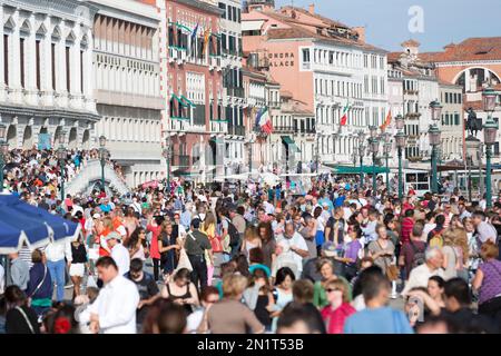 Italia, Venezia, folle lungo Riva degli Schiavoni vicino a Piazza San Marco. Foto Stock